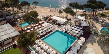 a pool and chairs on a beach