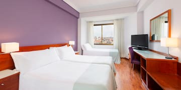 a room with two beds and a purple wall