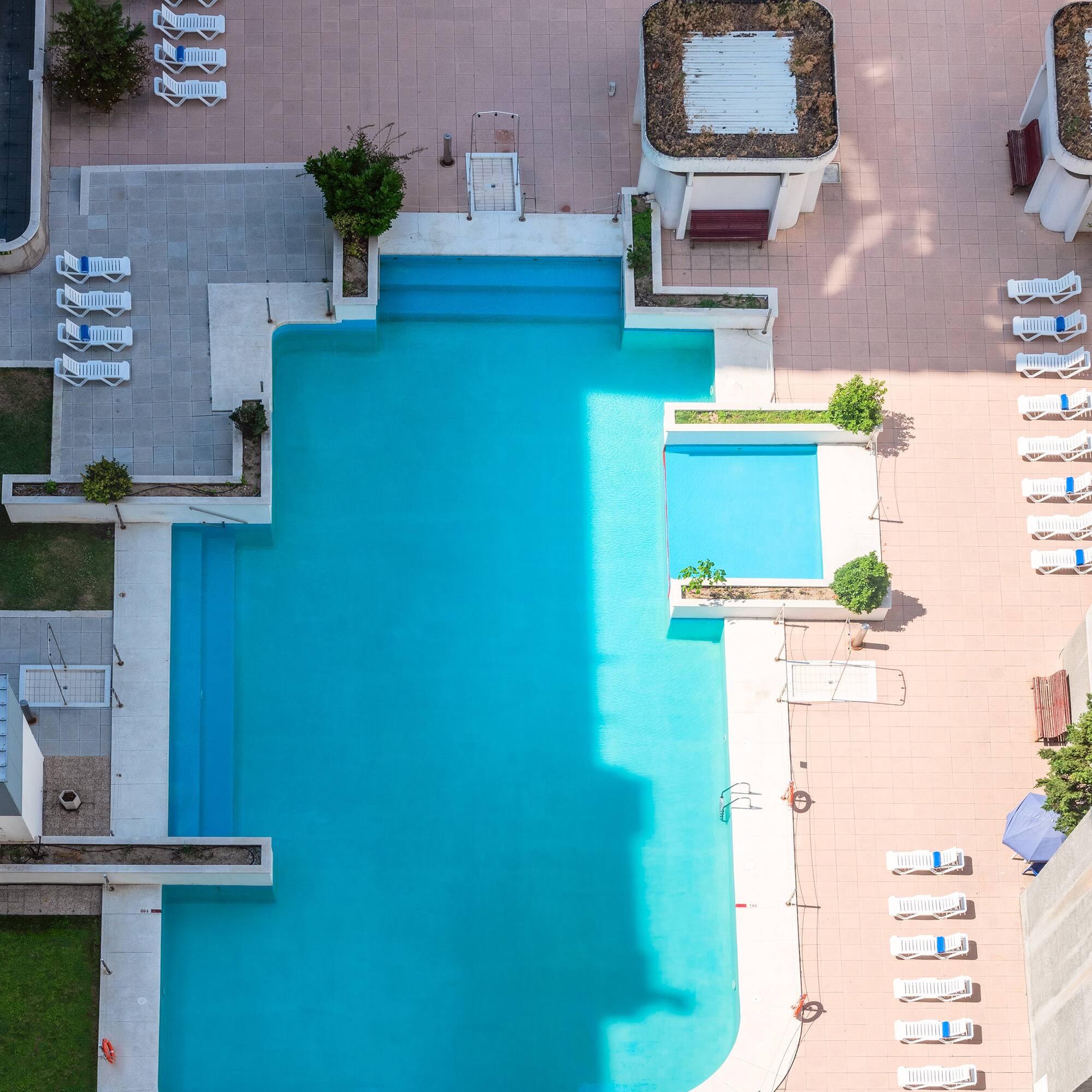 a pool with chairs and a building