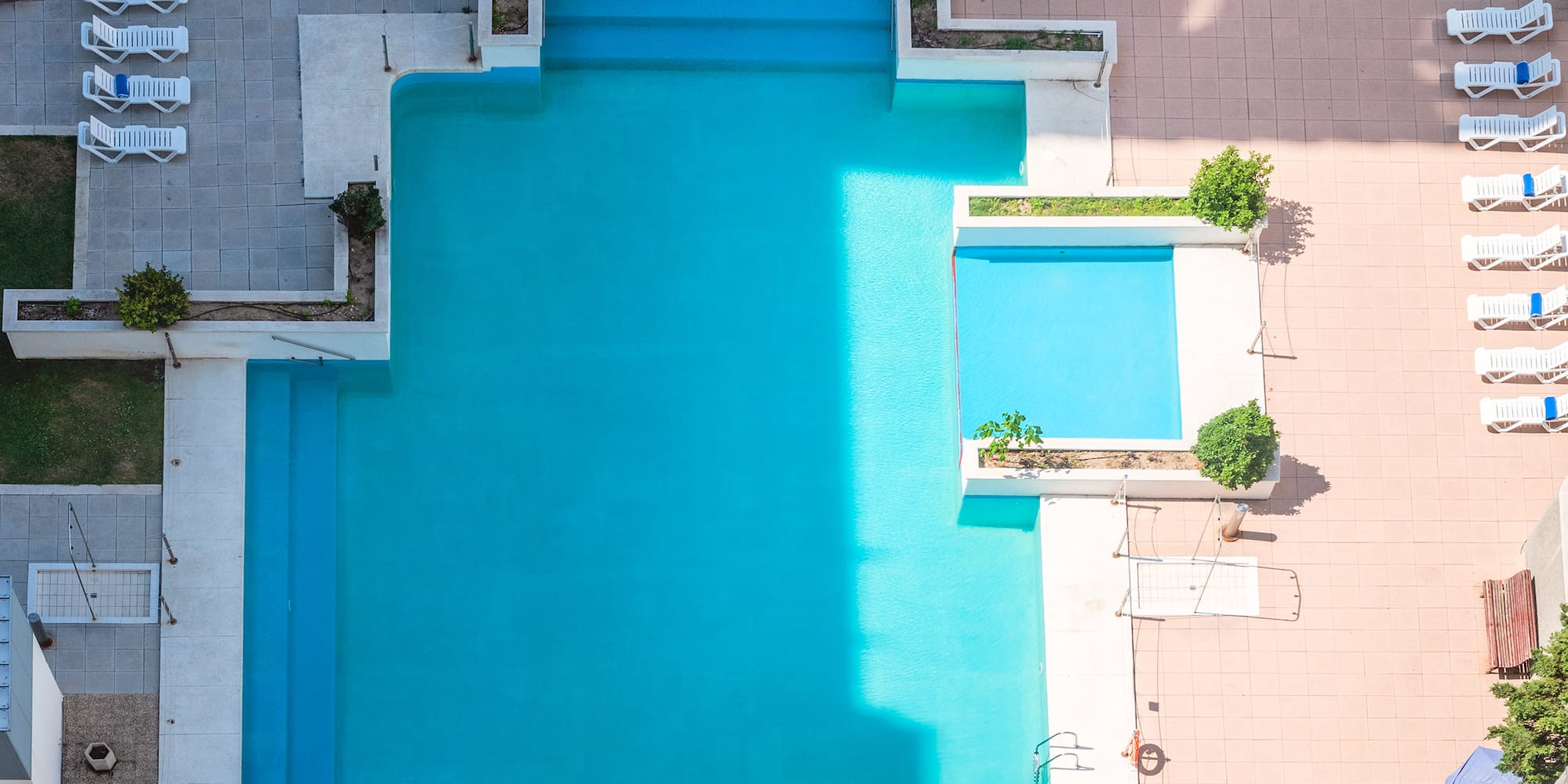 a pool with chairs and a building