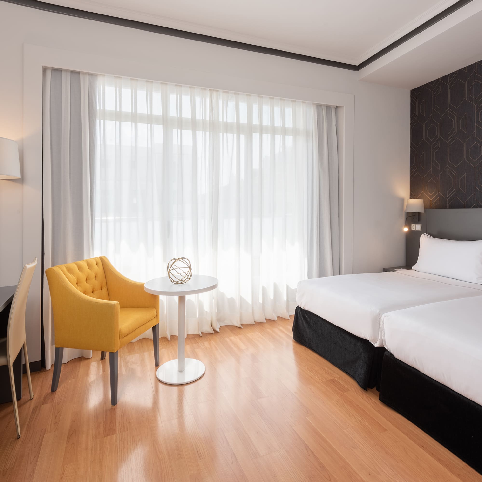 a room with two beds and a table and chair