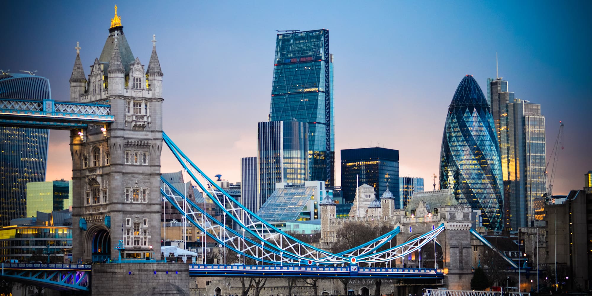 a bridge over water with a city skyline