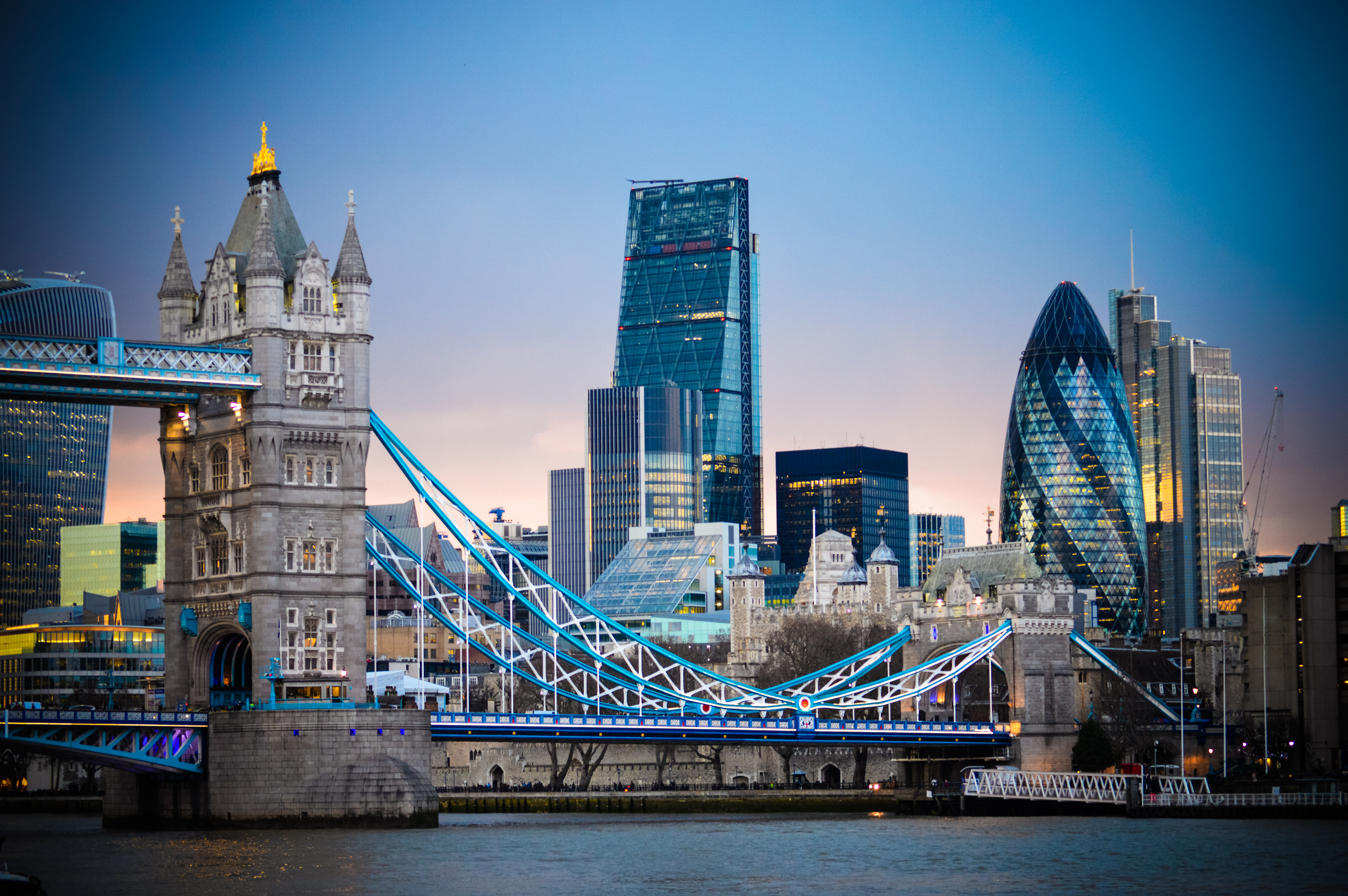 a bridge over water with a city skyline