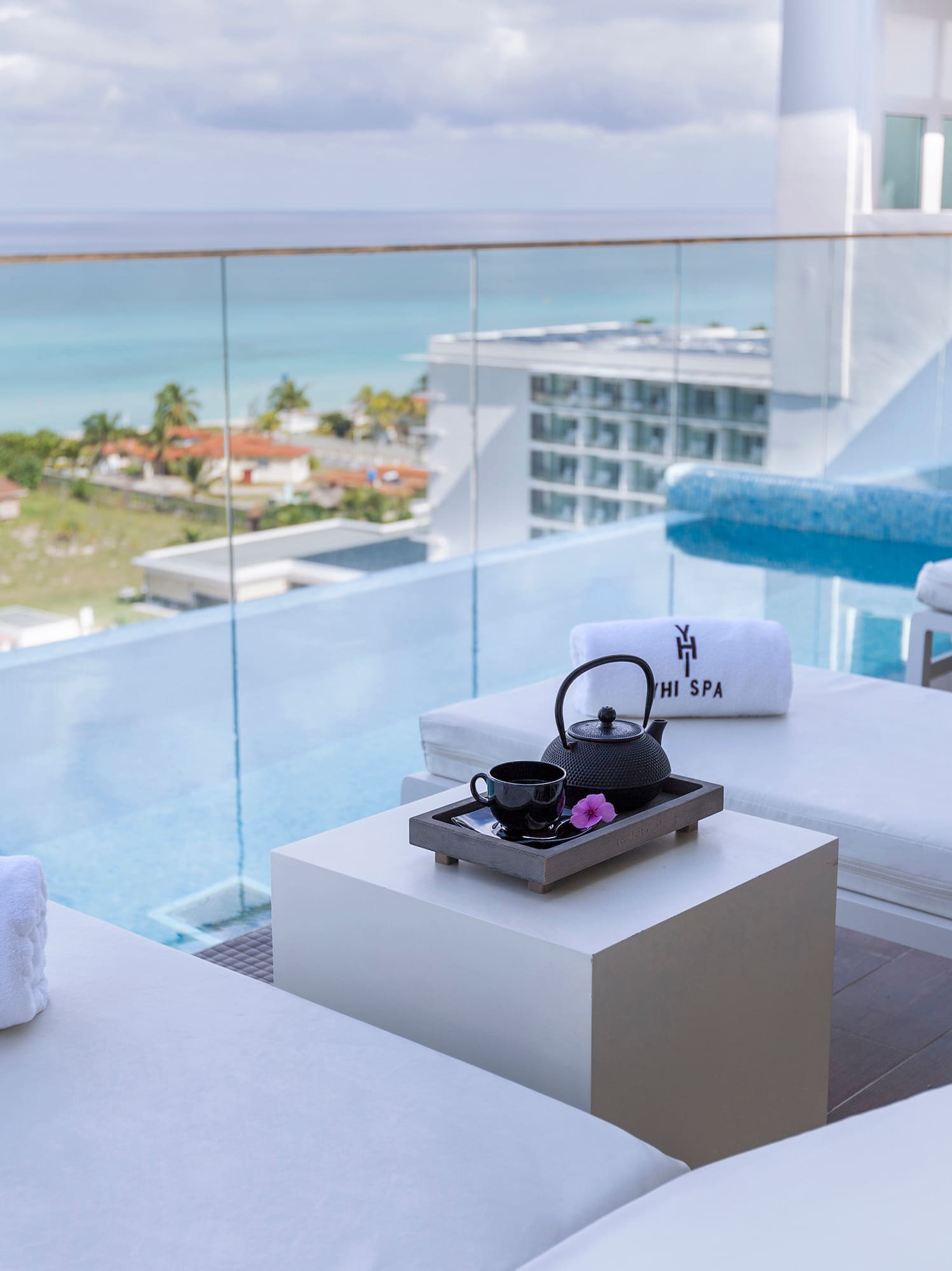 a pool with white chairs and towels