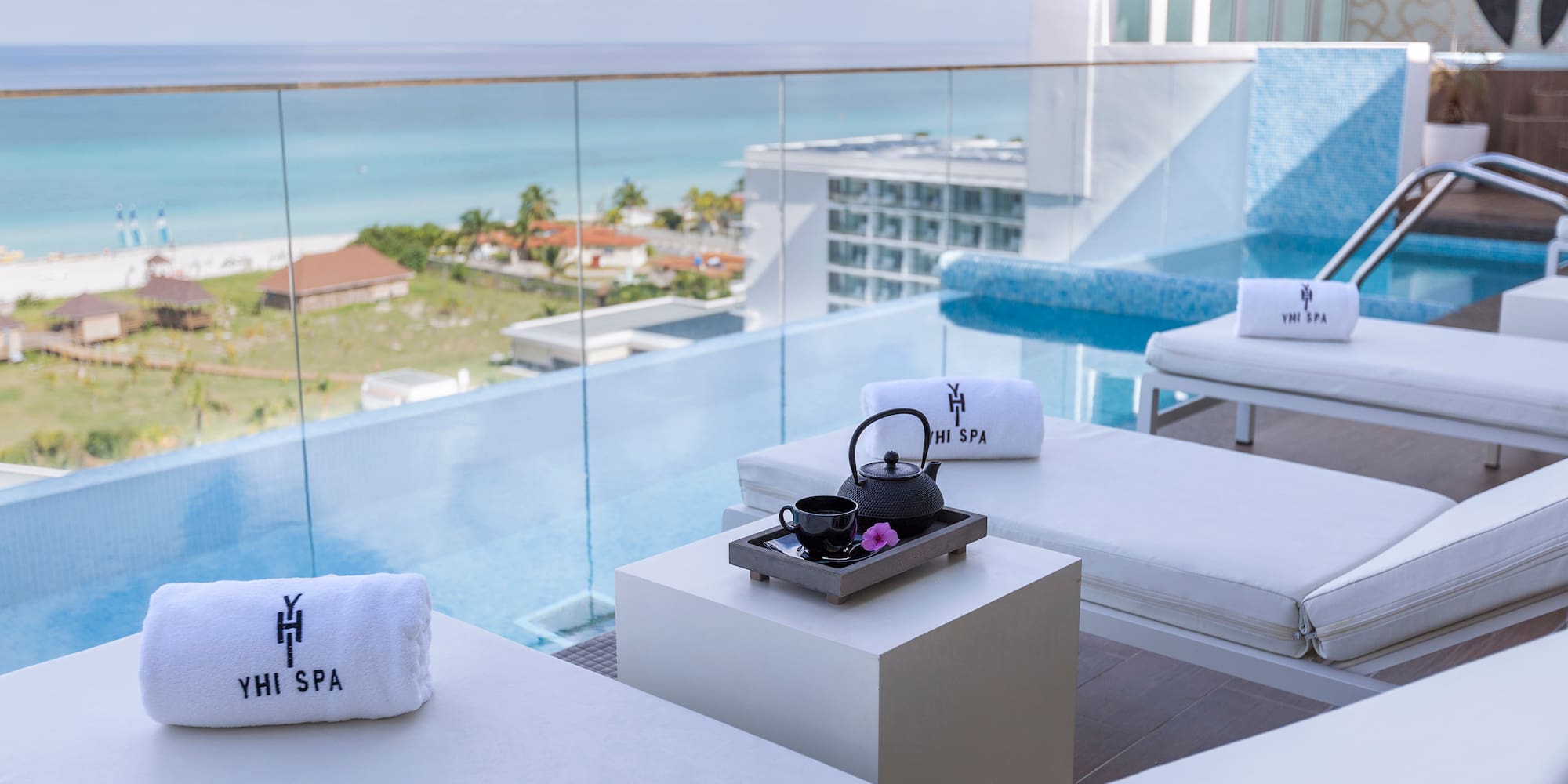 a pool with white chairs and towels