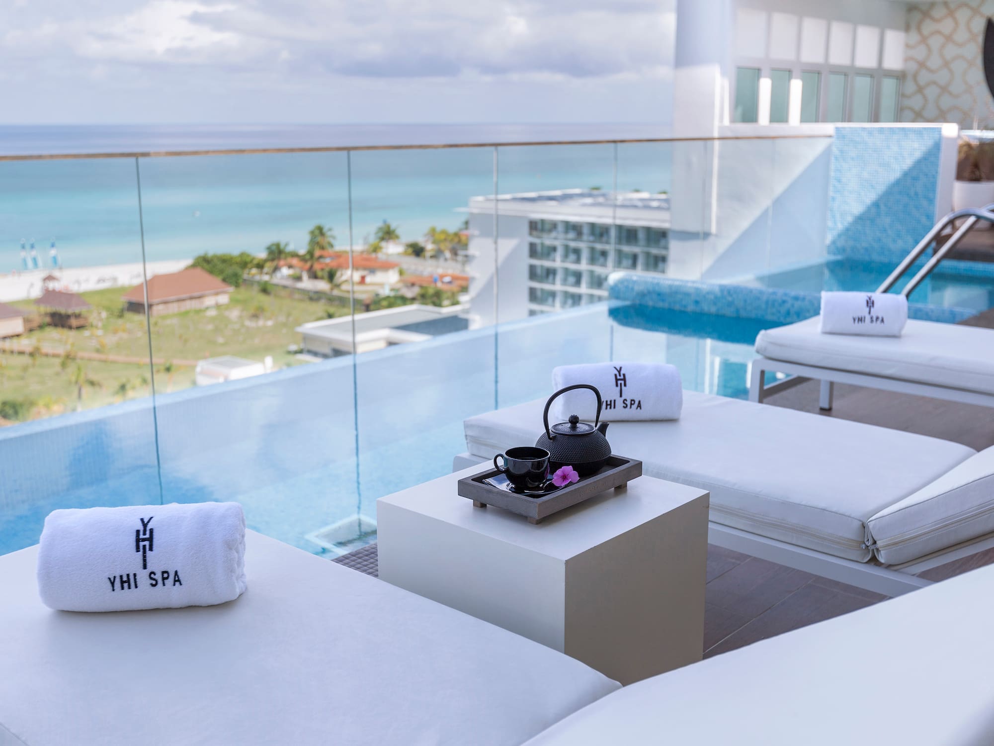 a pool with white chairs and towels