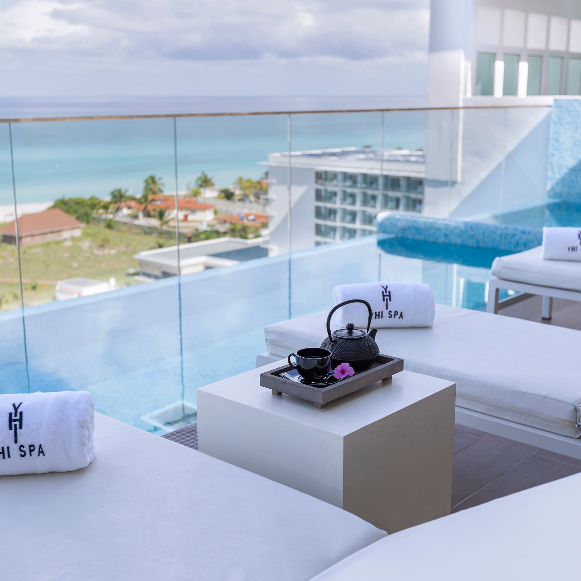 a pool with white chairs and towels