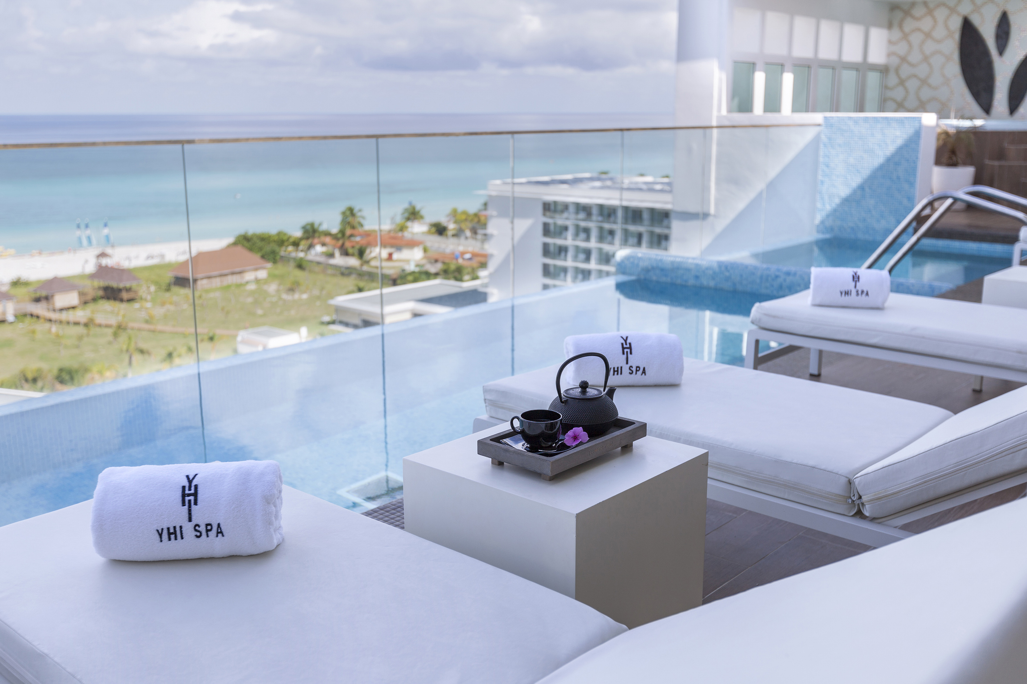 a pool with white chairs and towels