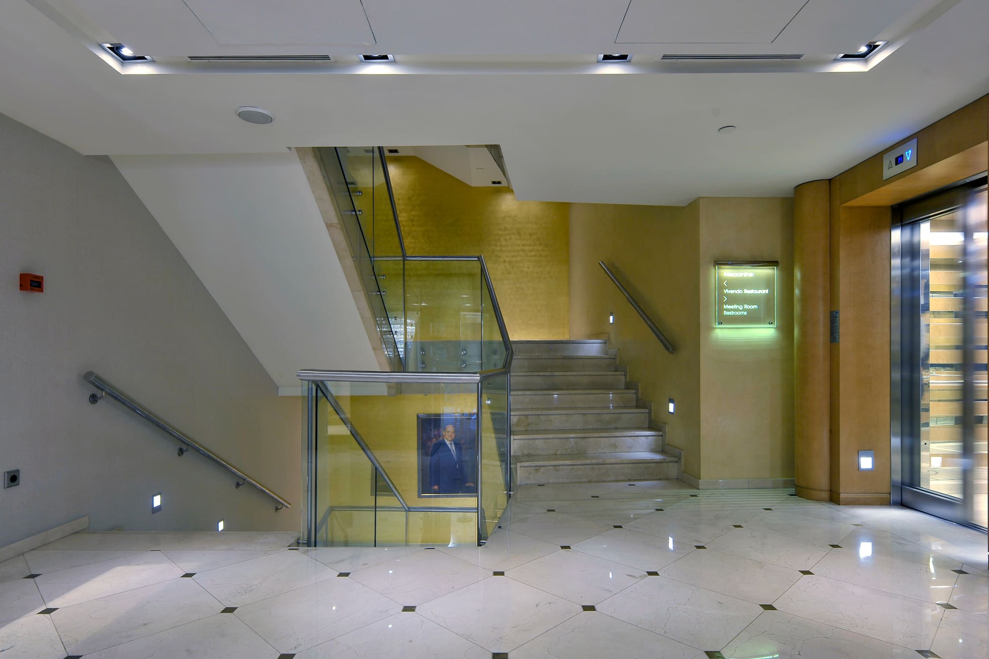 a staircase with glass railings and a man in a suit