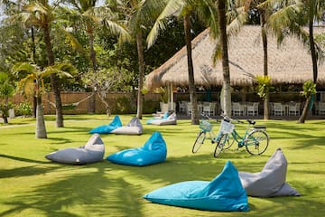 a group of bean bags on grass with trees and a bicycle