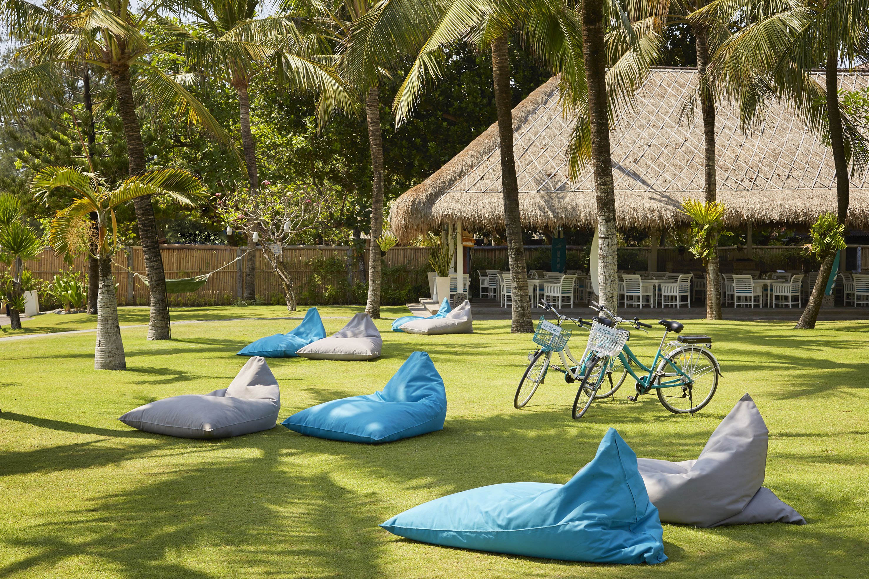 a group of bean bags on grass with trees and a bicycle