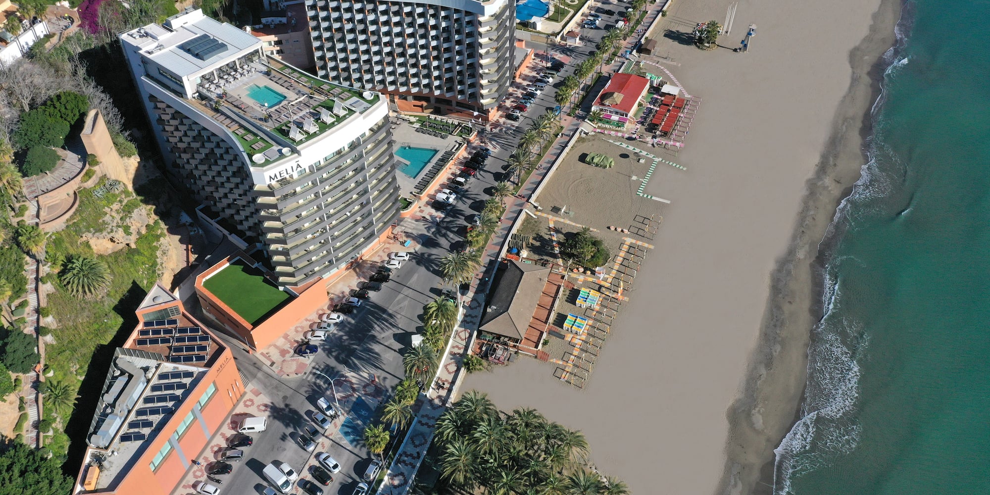 a beach with buildings and cars