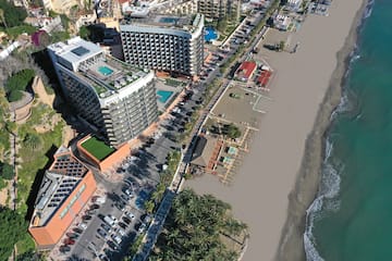a beach with buildings and cars