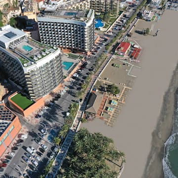 a beach with buildings and cars
