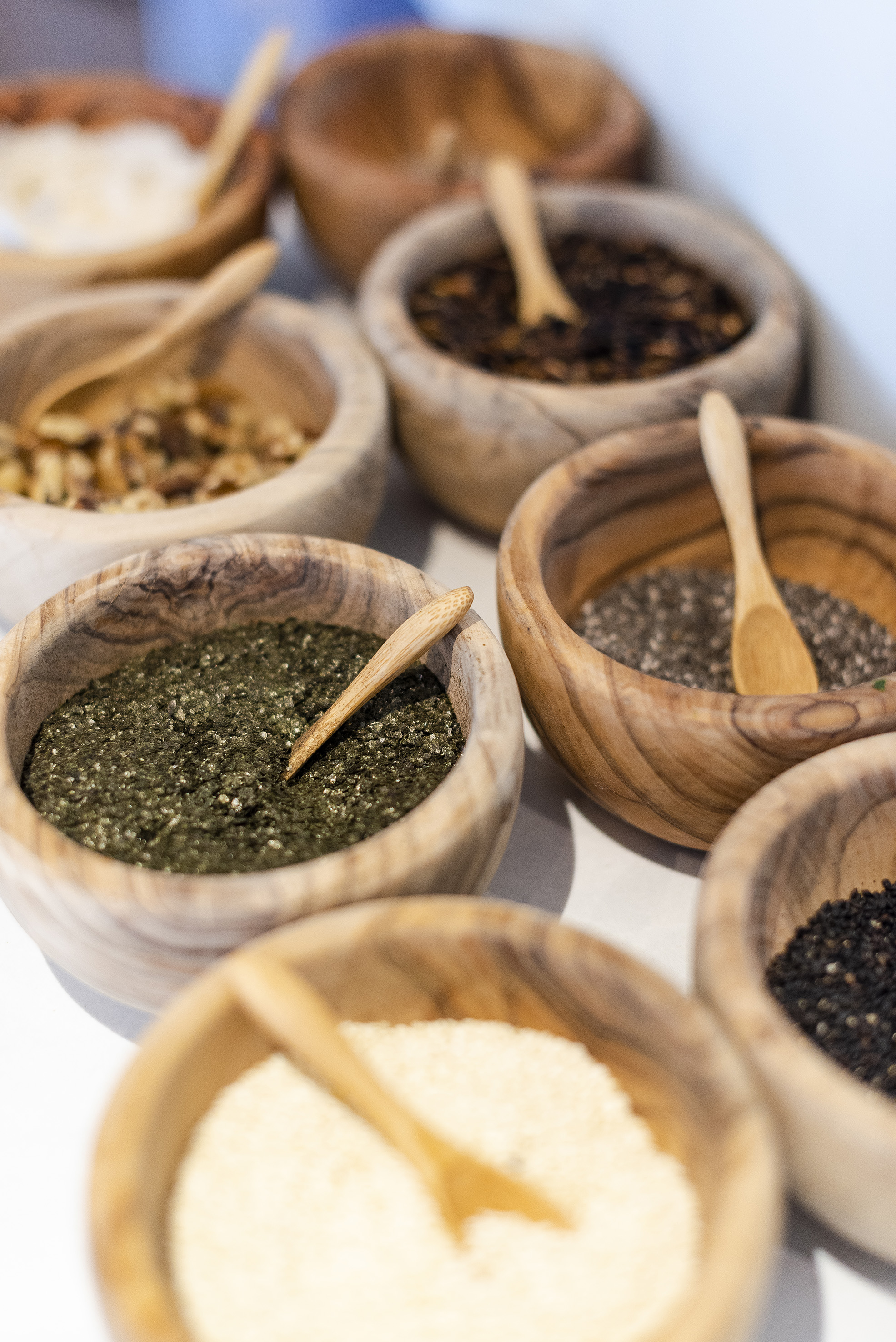 Wooden bowls with za'atar, chia, sesame, and other spices, seeds, nuts.