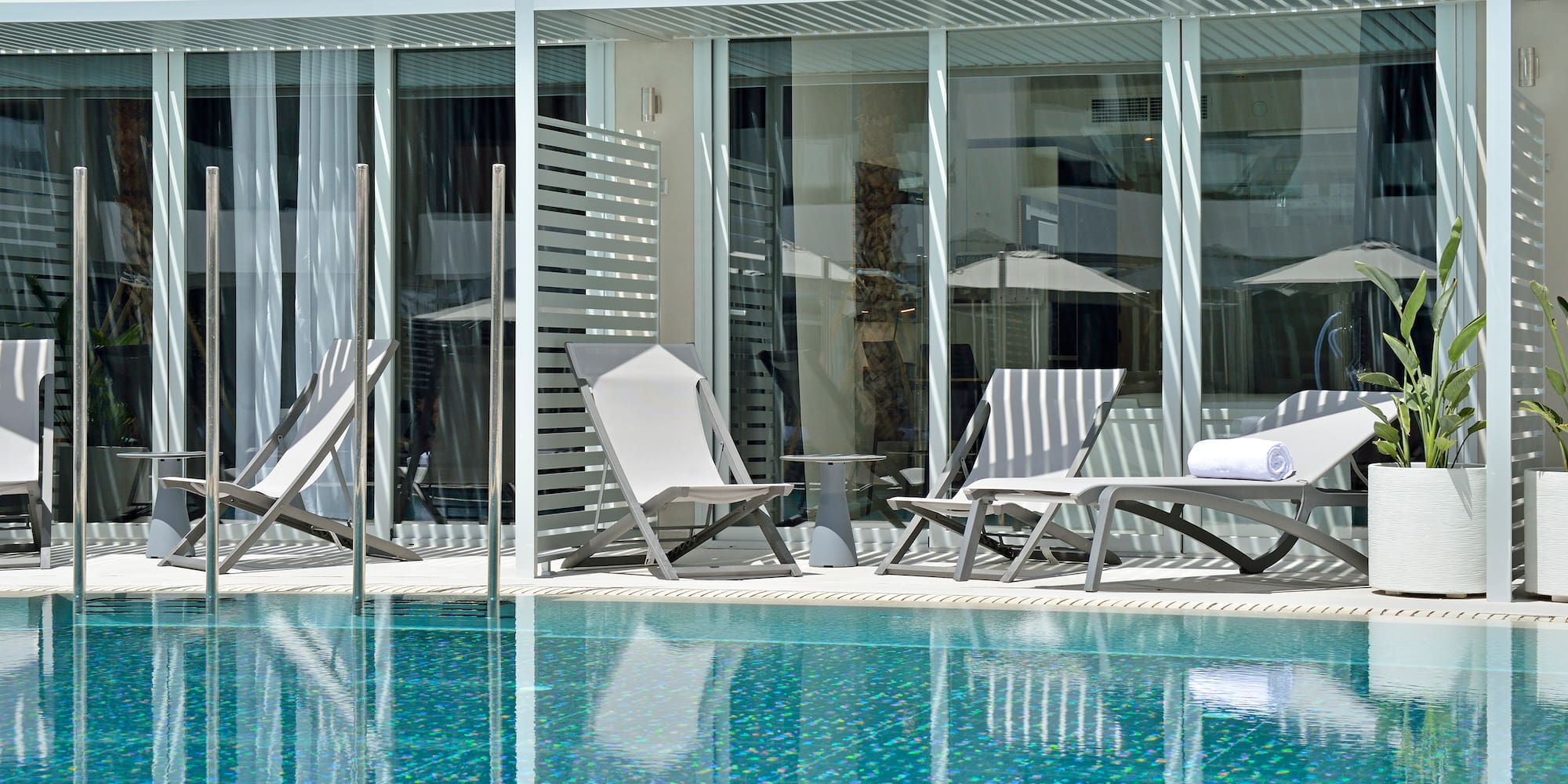 a pool with chairs and umbrellas