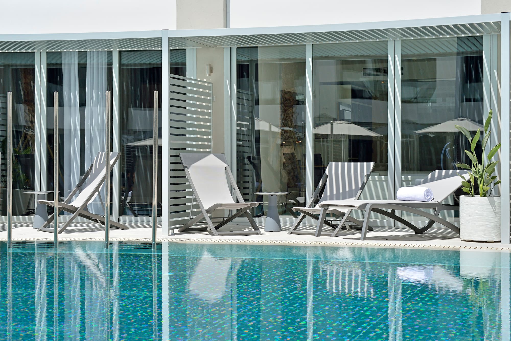 a pool with chairs and umbrellas