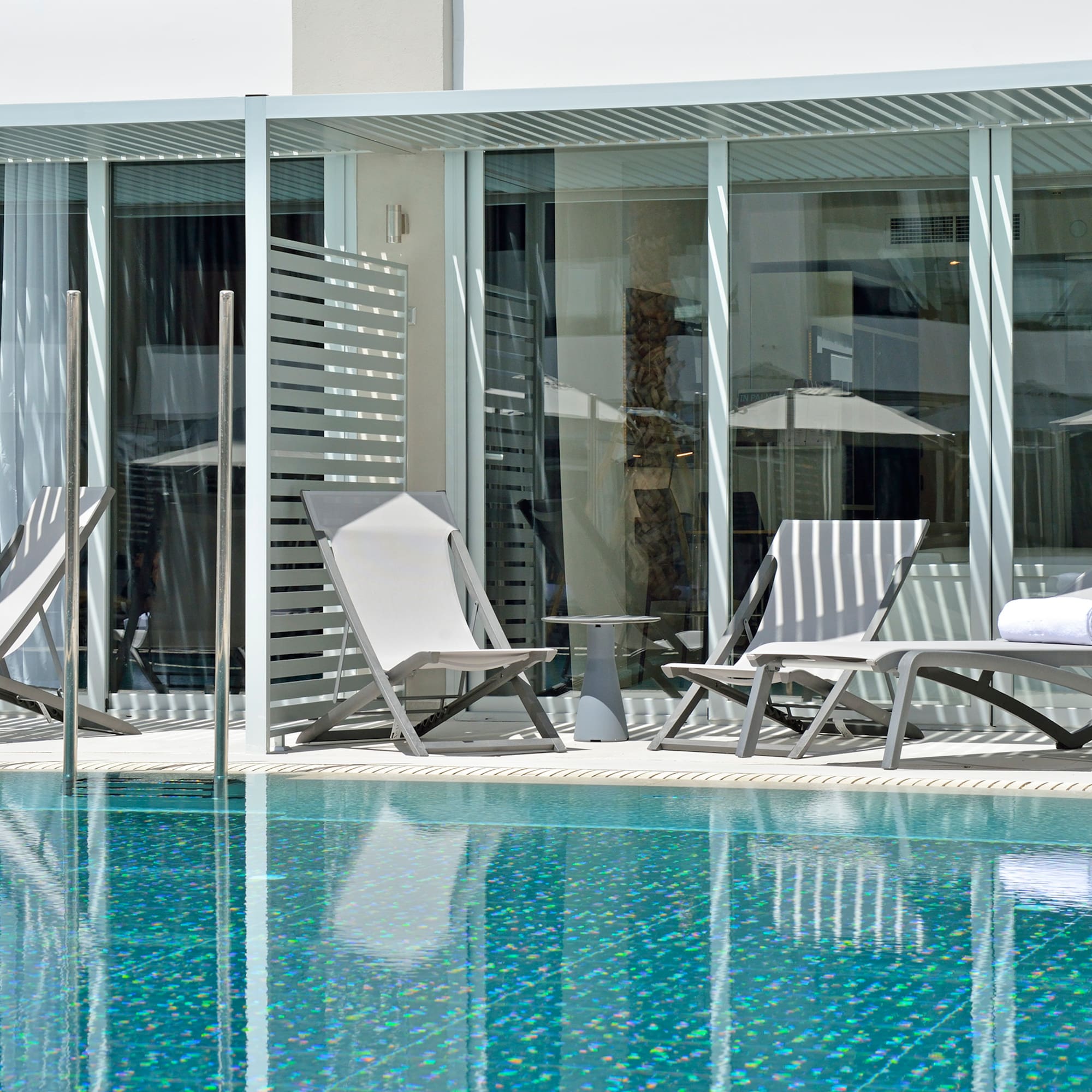 a pool with chairs and umbrellas