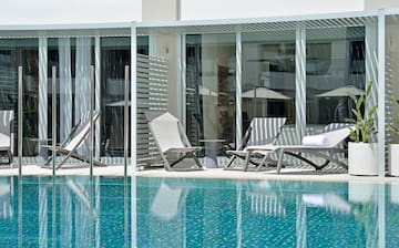 a pool with chairs and umbrellas