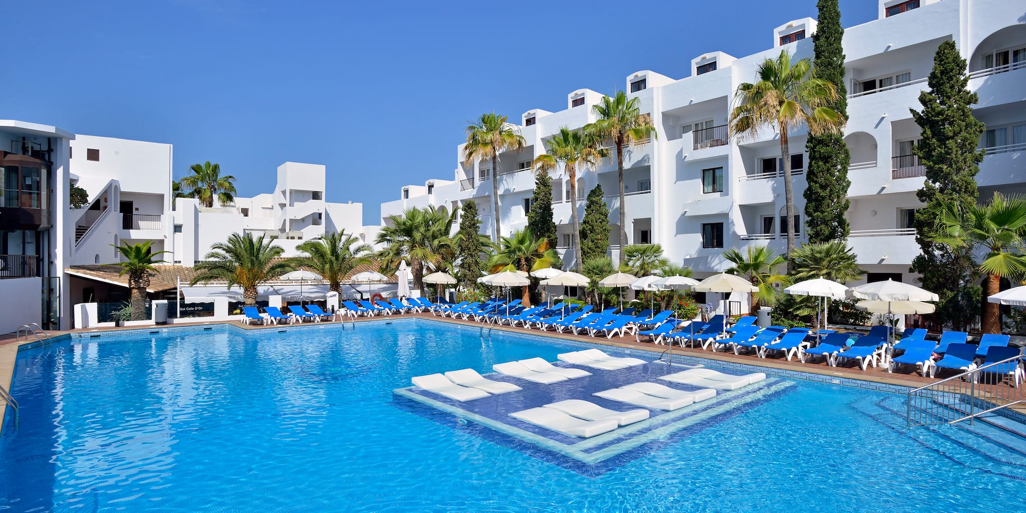 a pool with lounge chairs and a building in the background