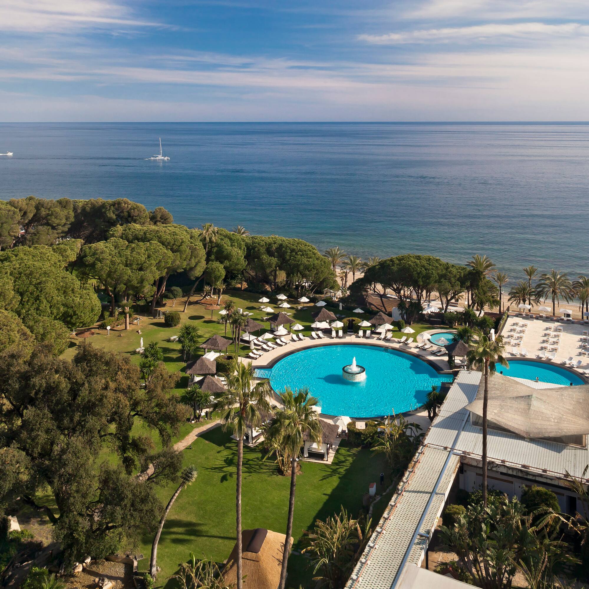 a swimming pool with trees and a body of water