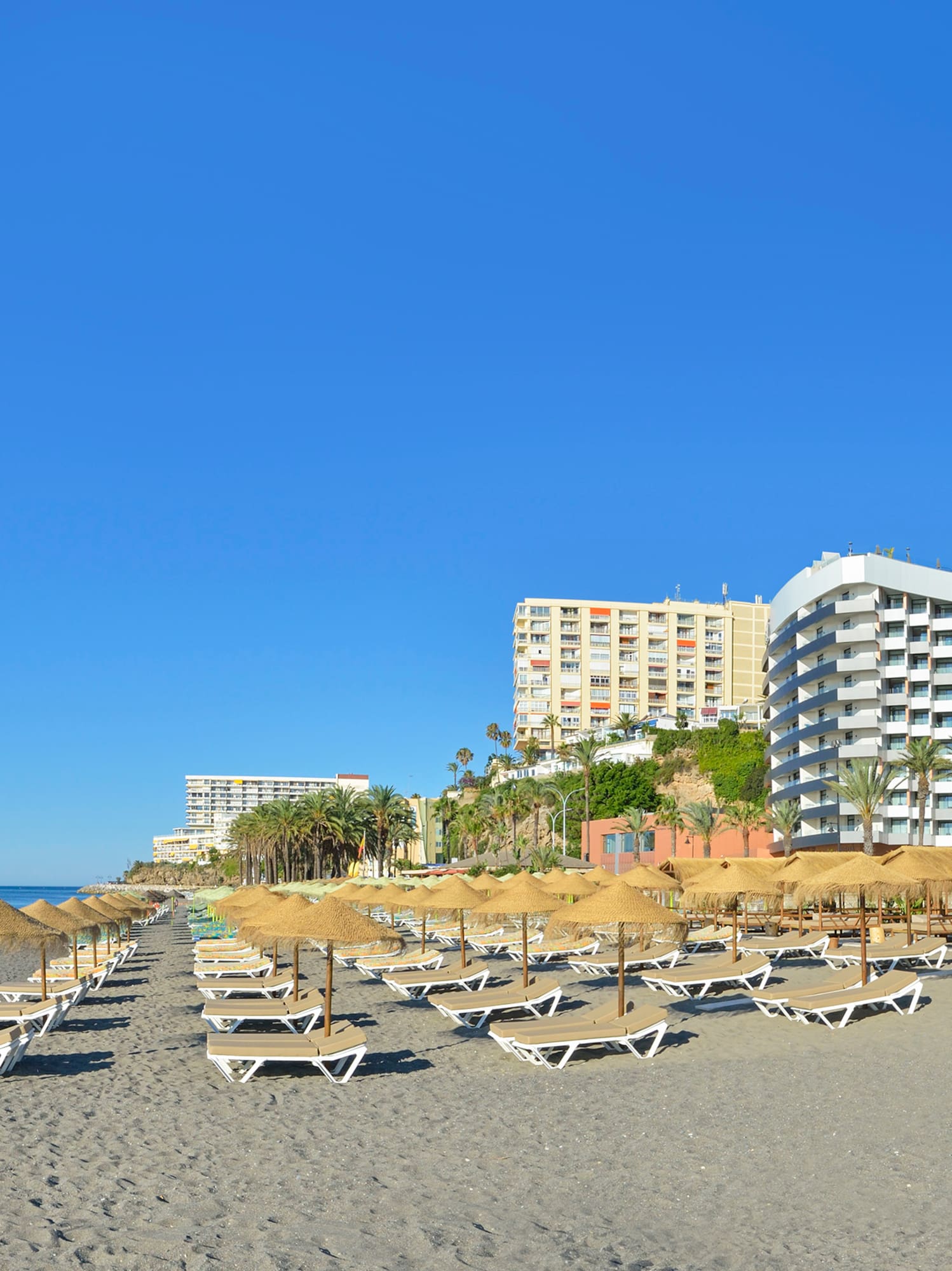 a beach with umbrellas and lounge chairs