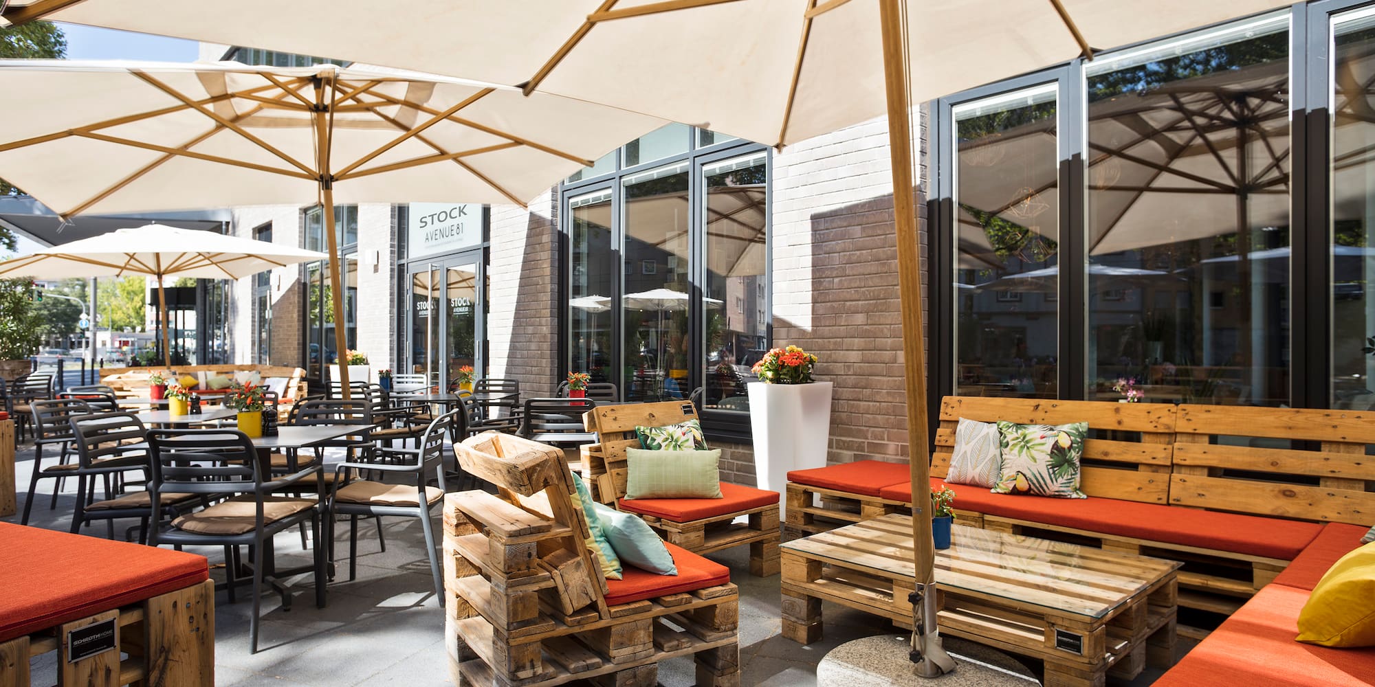 a patio with wooden pallets and umbrellas