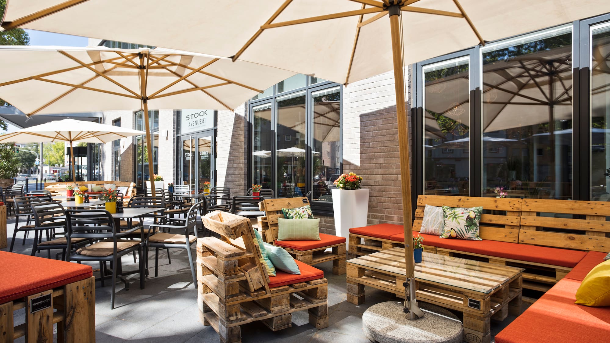 a patio with wooden pallets and umbrellas