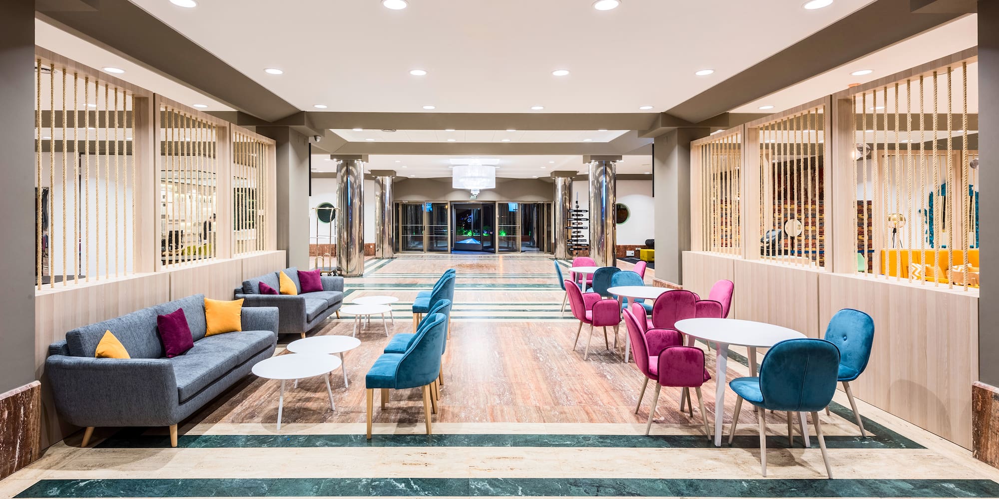a room with a large lobby with tables and chairs