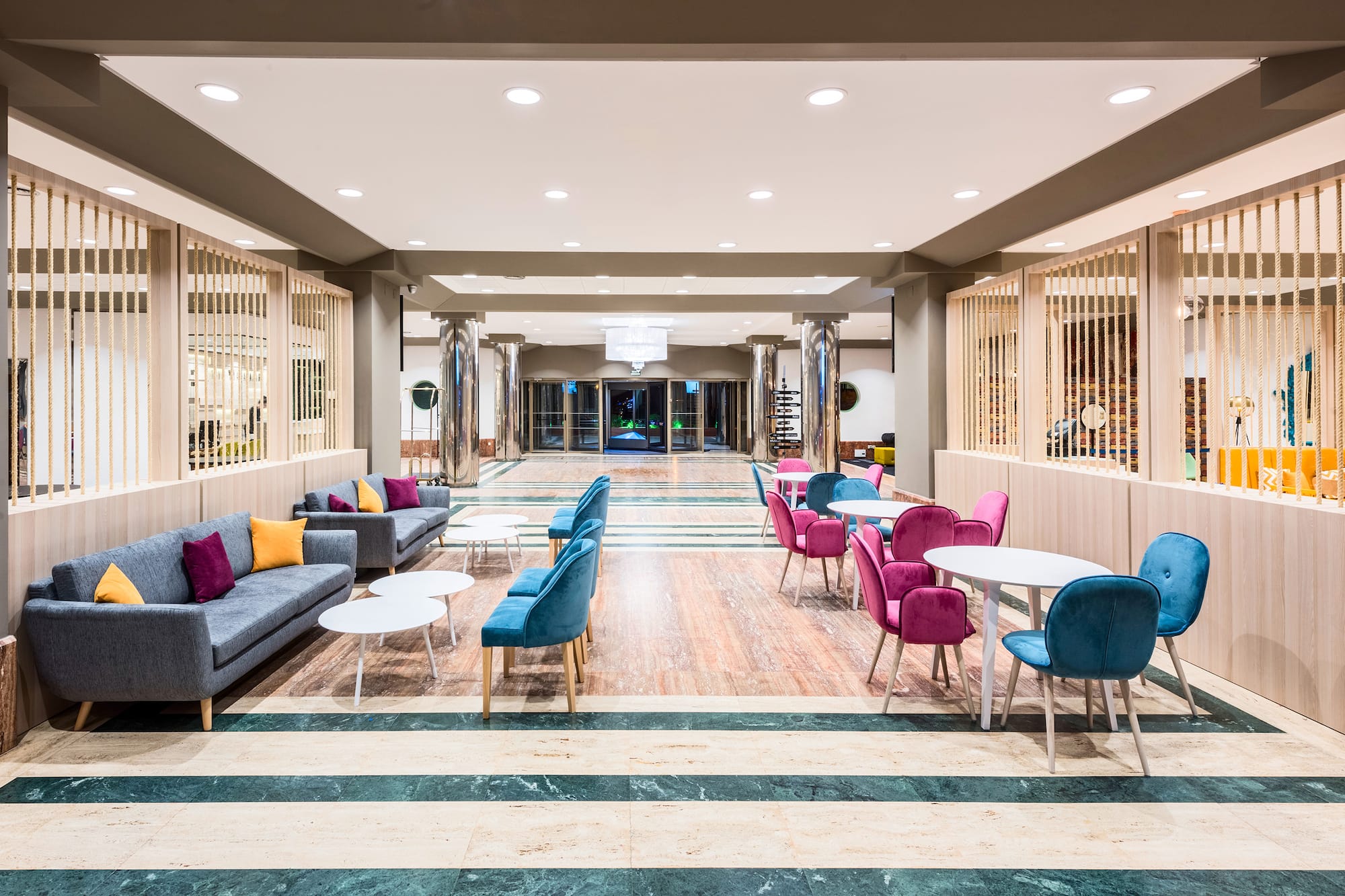 a room with a large lobby with tables and chairs