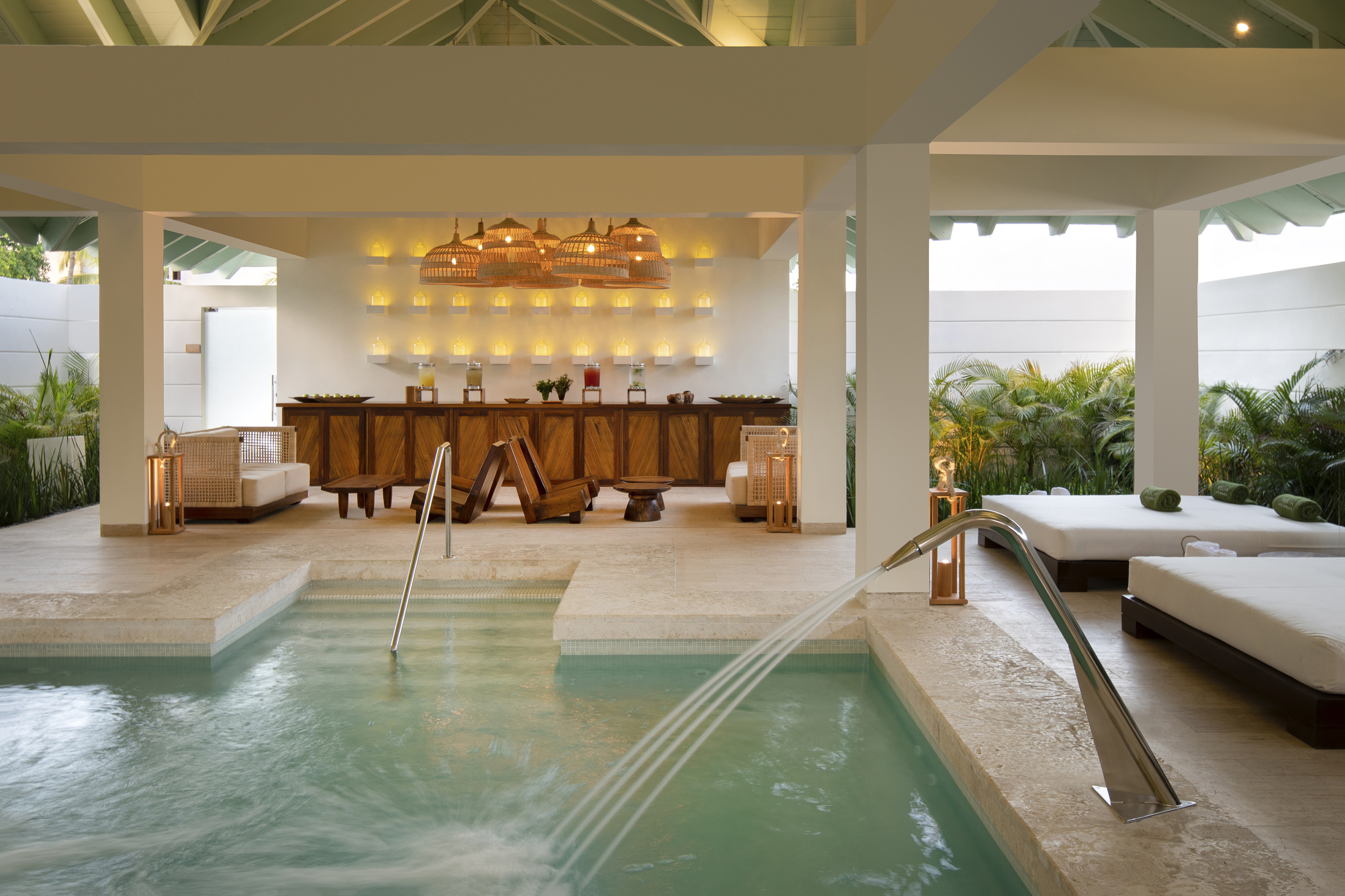 Luxury resort spa with hydrotherapy pool, lounge beds, and warm lighting.