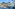 Luxury tropical resort with large swimming pool, palm trees, and ocean view.