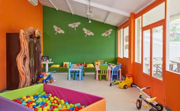 a room with a playroom with a ball pit and toys