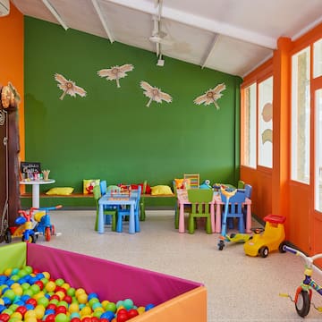 a room with a playroom with a ball pit and toys
