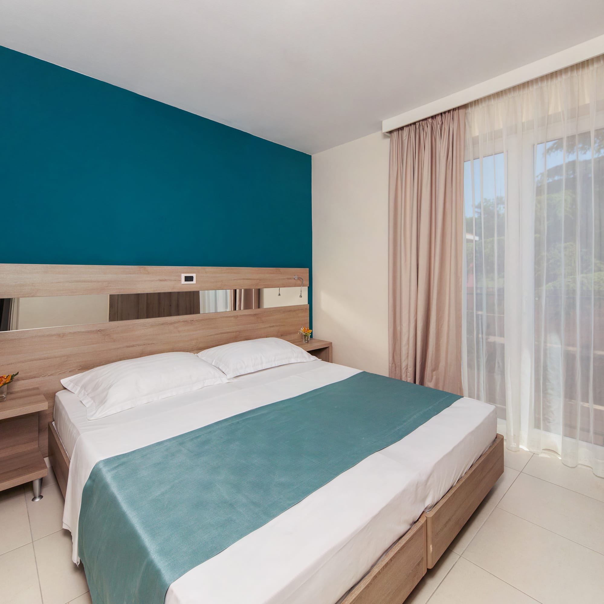 a bed with a blue blanket and a wood headboard