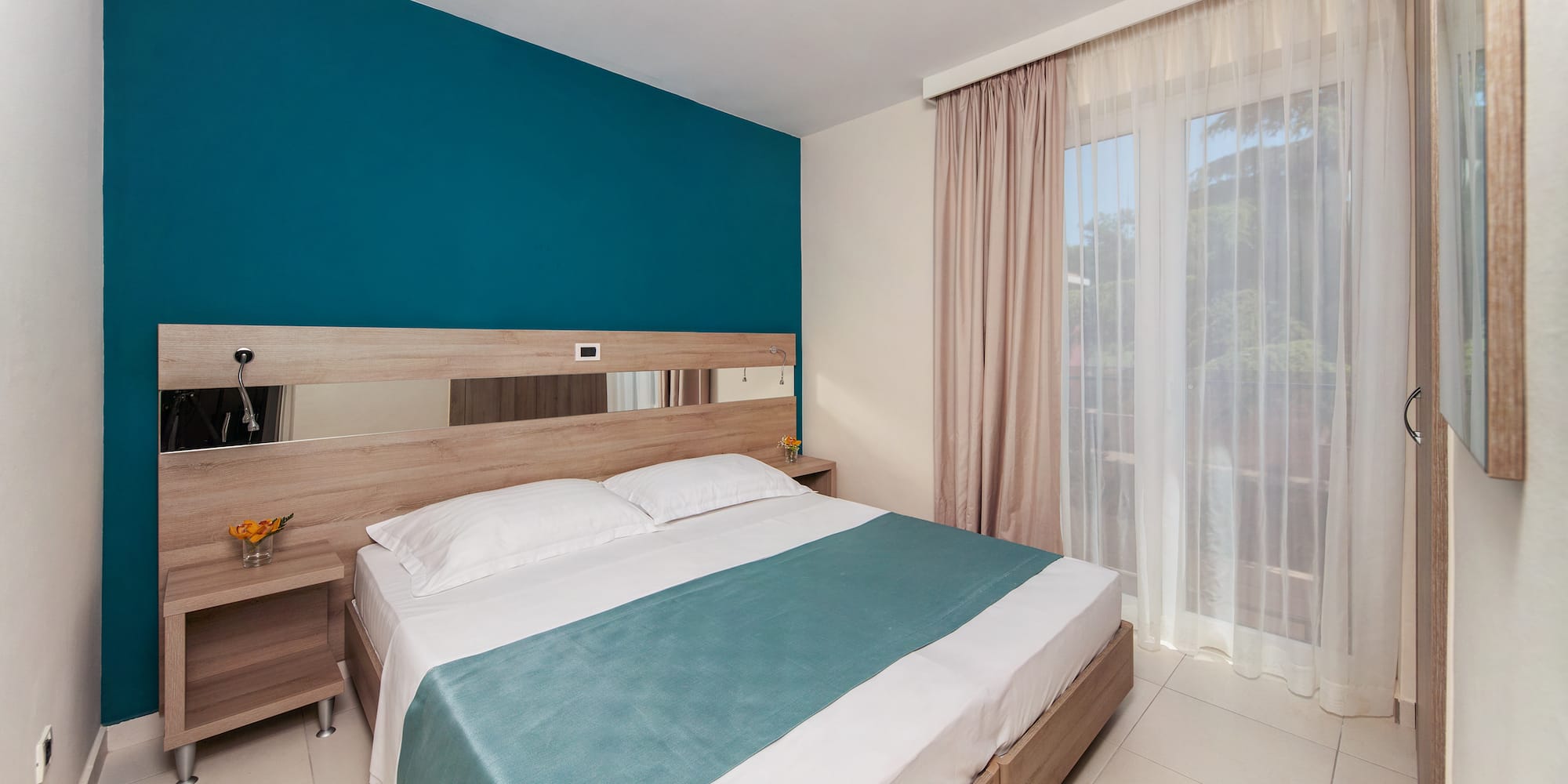 a bed with a blue blanket and a wood headboard