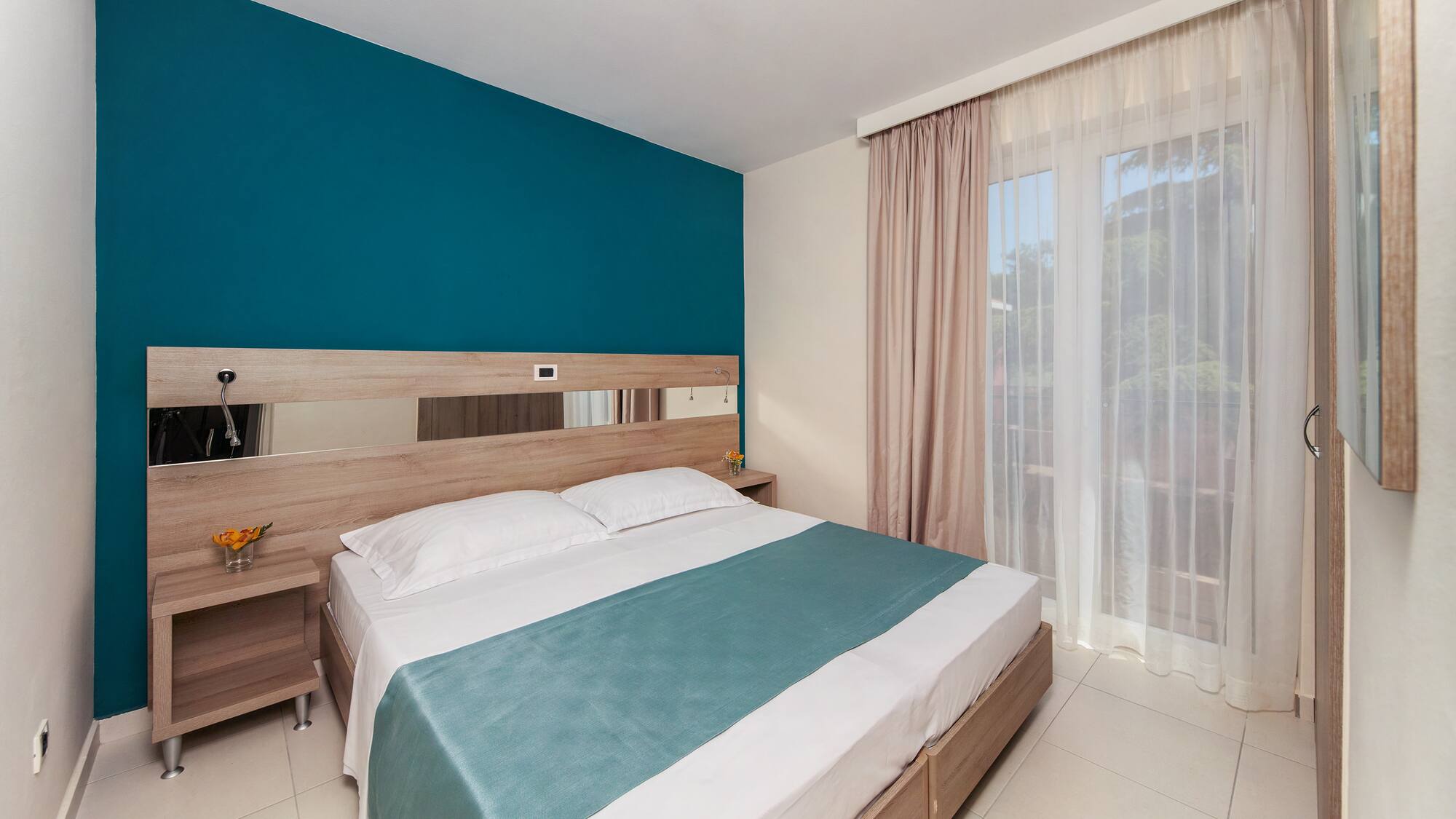 a bed with a blue blanket and a wood headboard