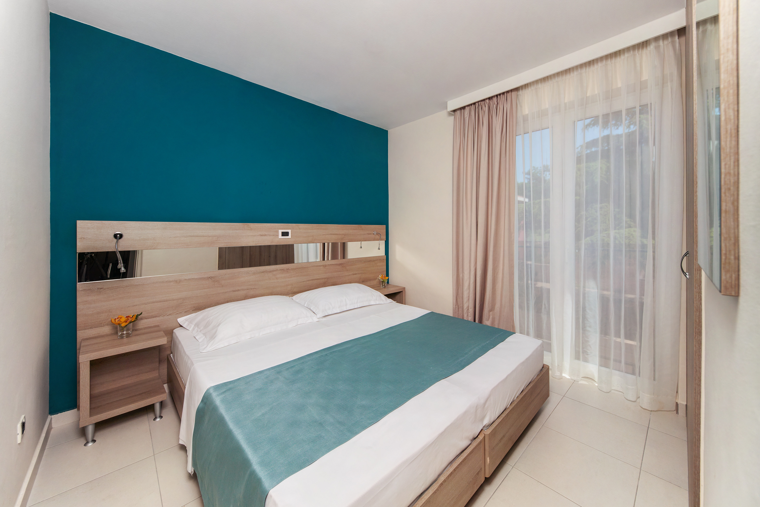 a bed with a blue blanket and a wood headboard