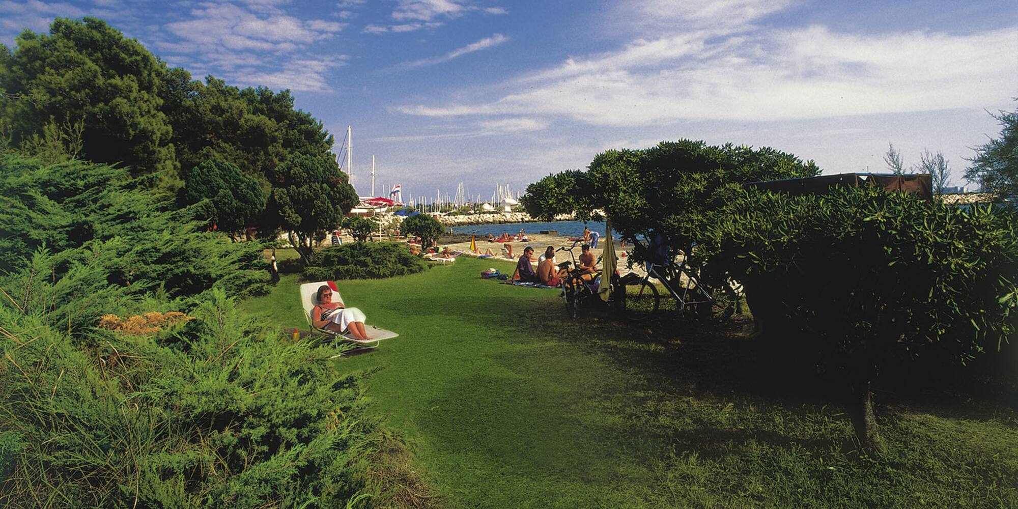 a group of people sitting in chairs on a lawn