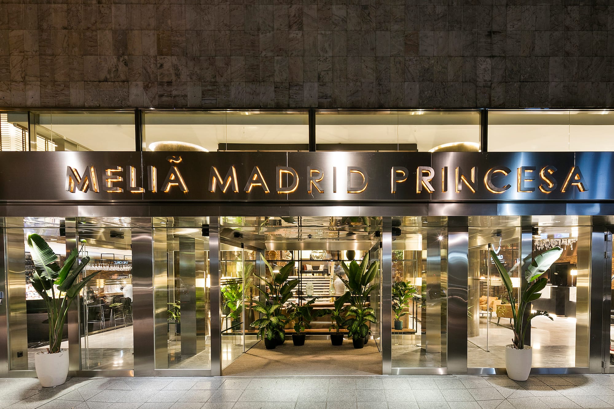 Illuminated Meliá Madrid Princesa hotel entrance in Madrid.