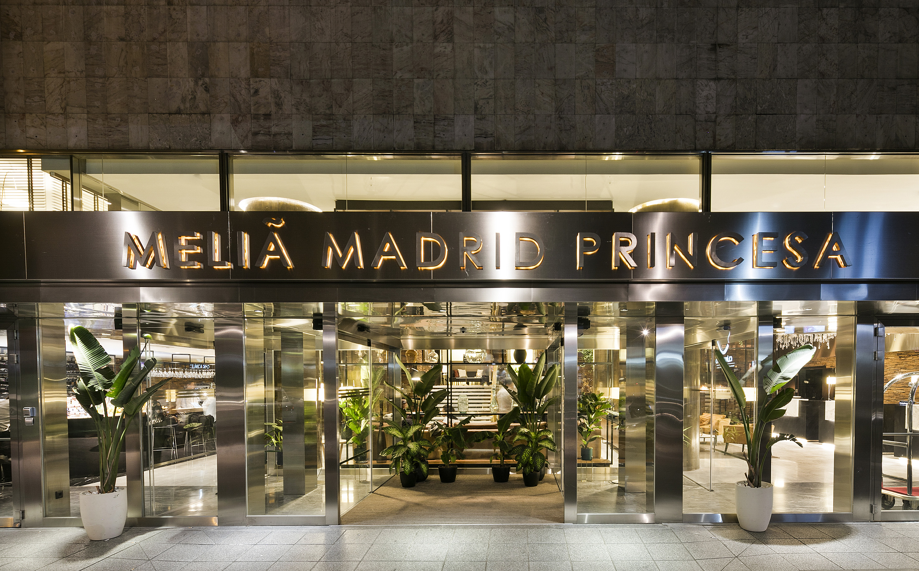 Illuminated Meliá Madrid Princesa hotel entrance in Madrid.