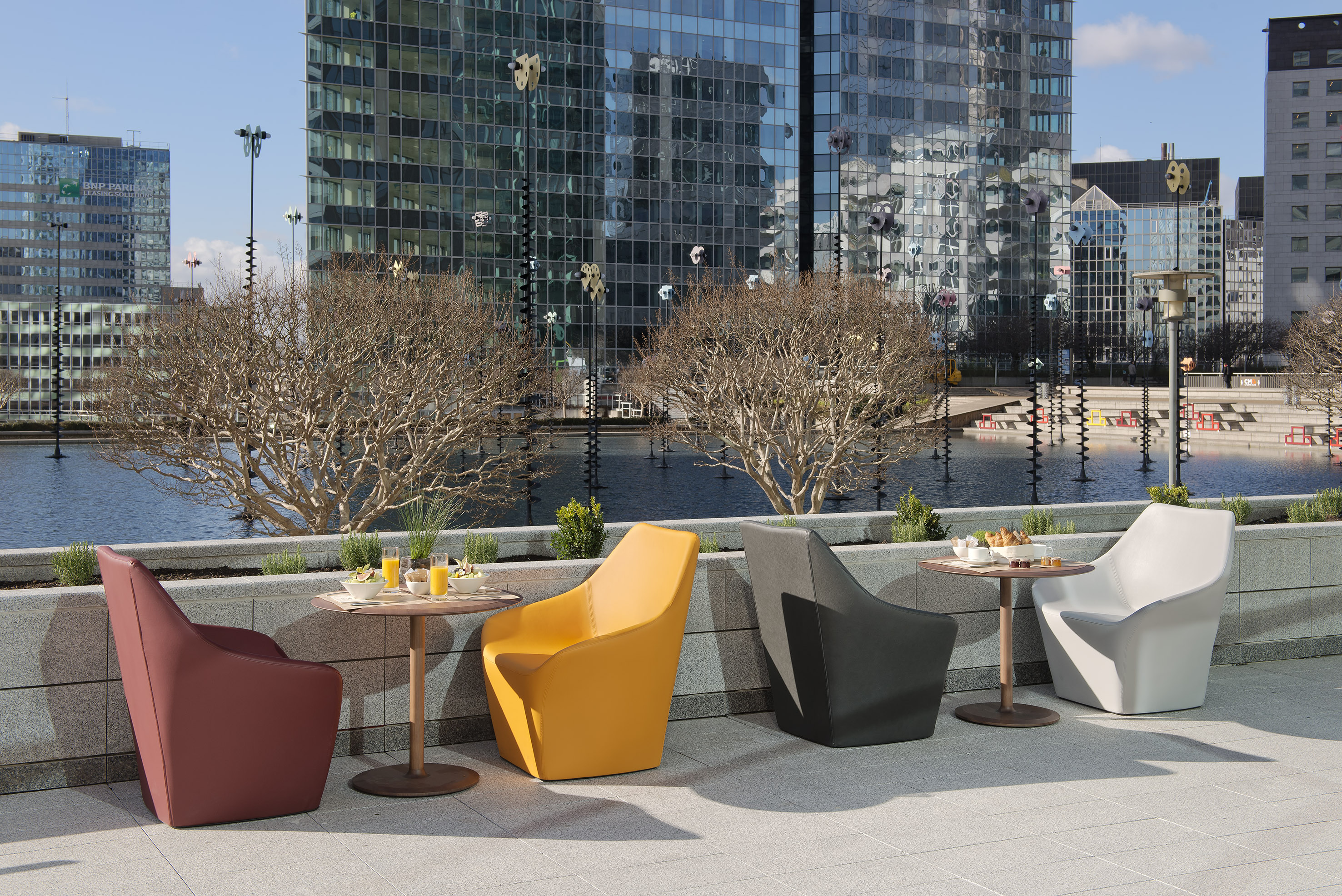 Modern outdoor chairs, tables, and breakfast on an urban patio.