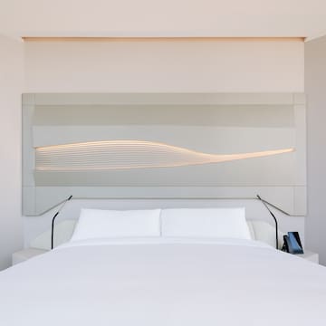 a bed with a white bedding and a white wall