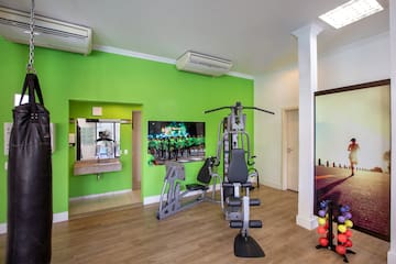 a room with exercise equipment and a green wall