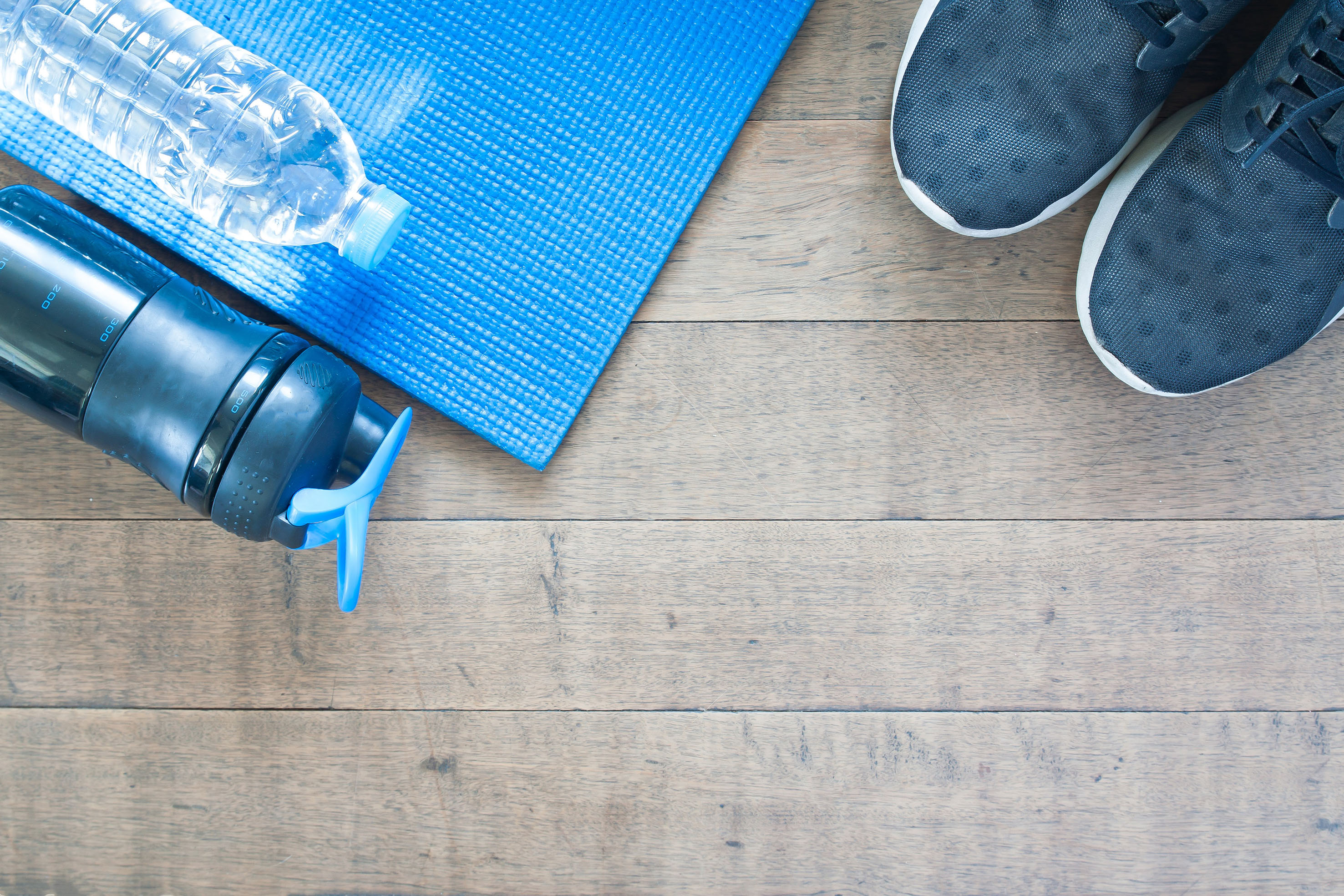 a blue mat and water bottle on a wooden floor