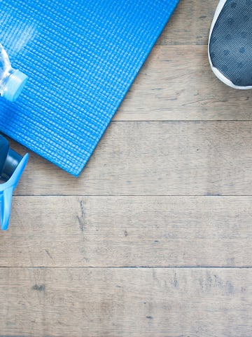 a blue mat and water bottle on a wooden floor