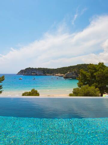 a pool overlooking a beach and trees