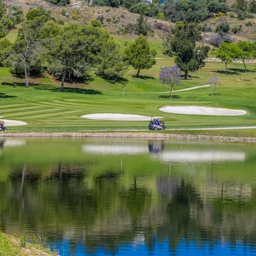 a golf course with a lake and trees