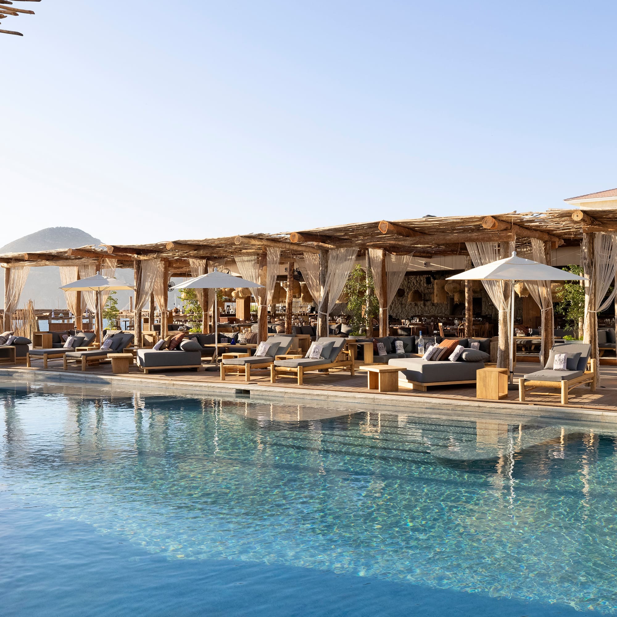 a pool with lounge chairs and umbrellas