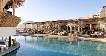 a pool with lounge chairs and umbrellas